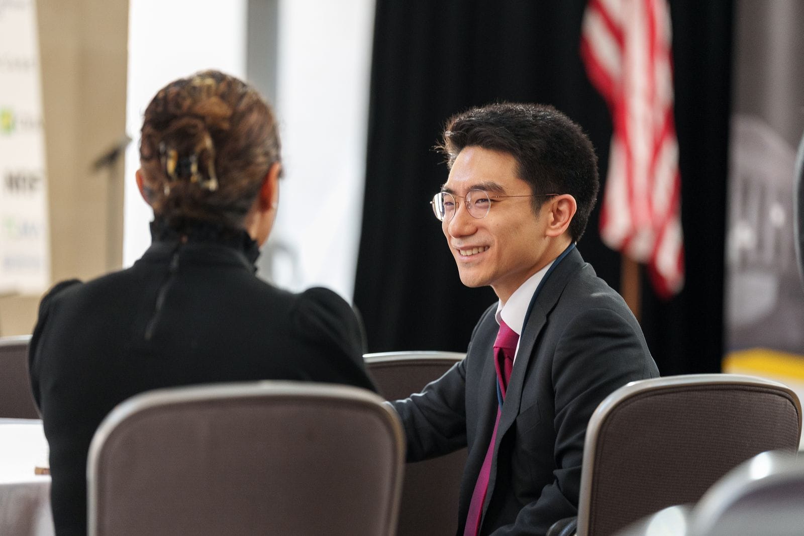 Two attendees seated together, smiling and talking during a WITA networking event
